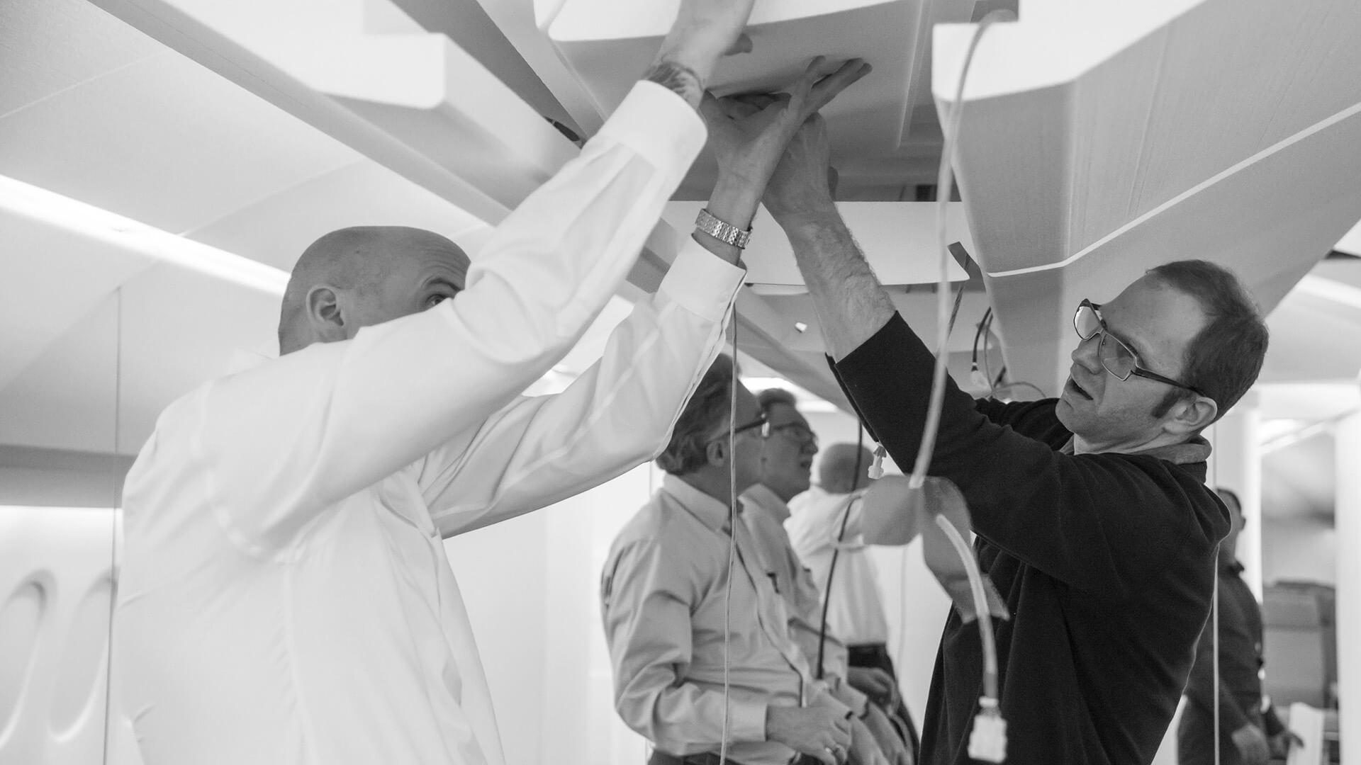 Men putting together airplane stowage bin