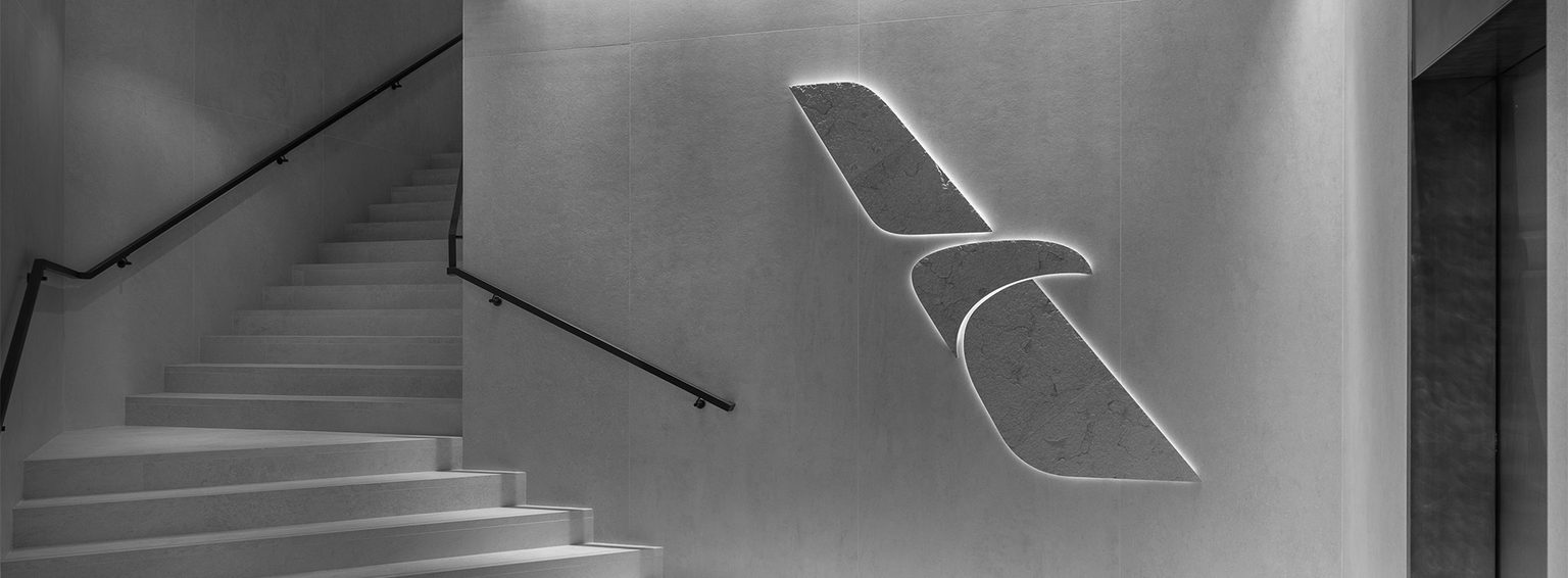 Office of American Airlines with staircase and large backlit brand logo on the wall