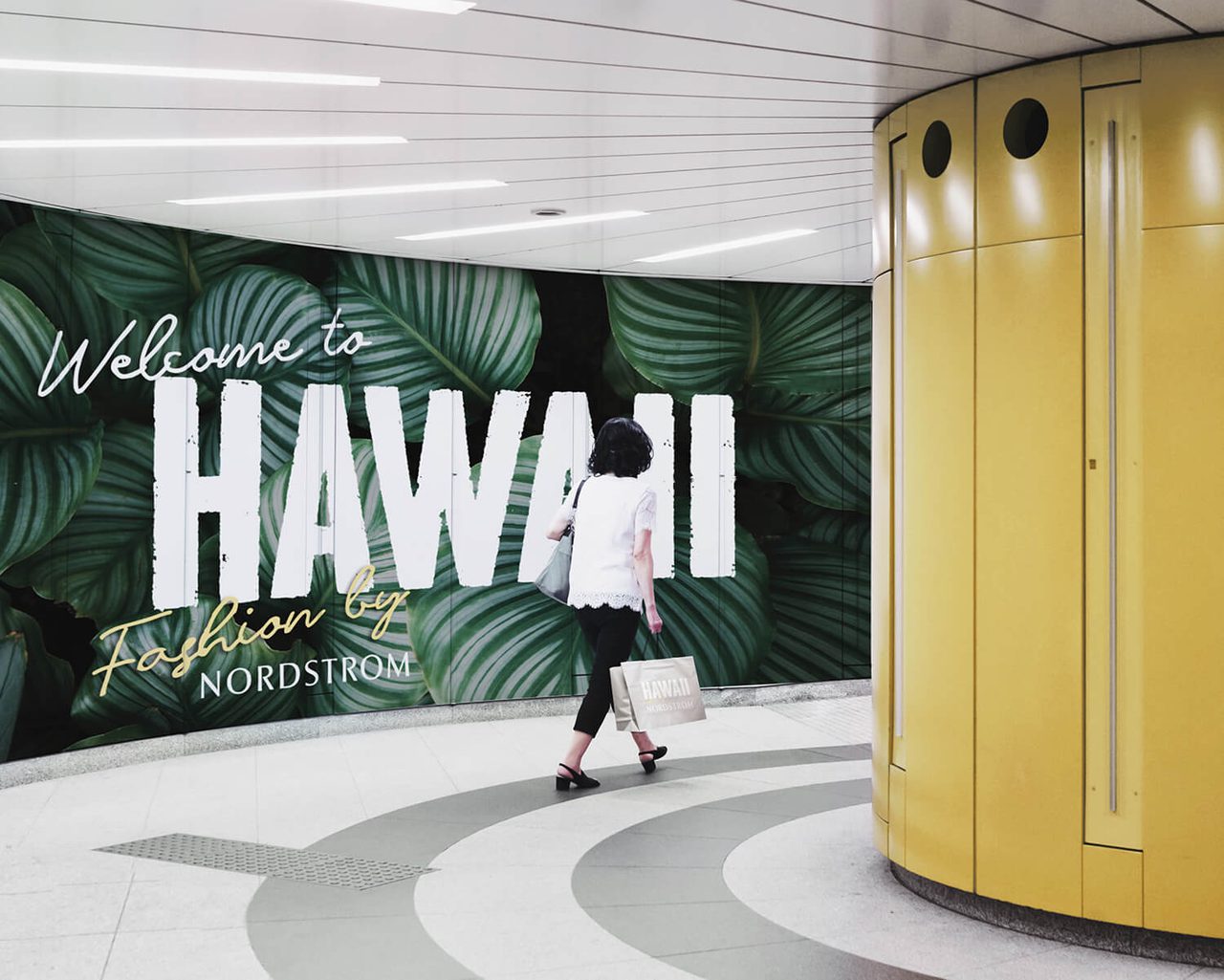 Women walking through airport with Nordstrom welcome sign