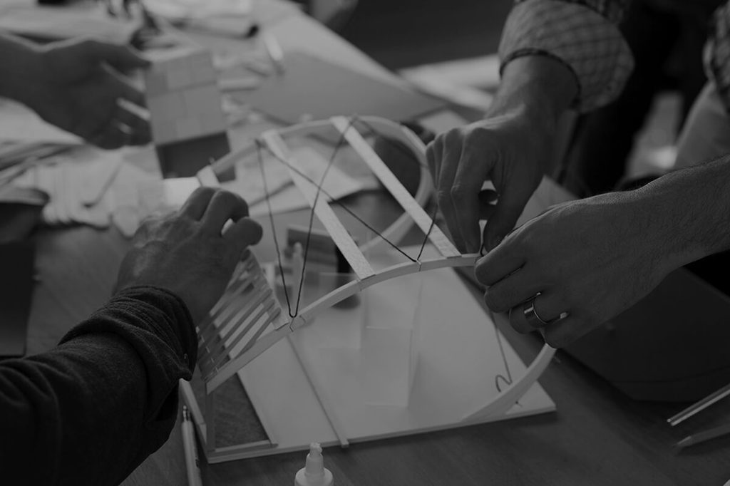 Two pairs of hands building a small 3D prototype