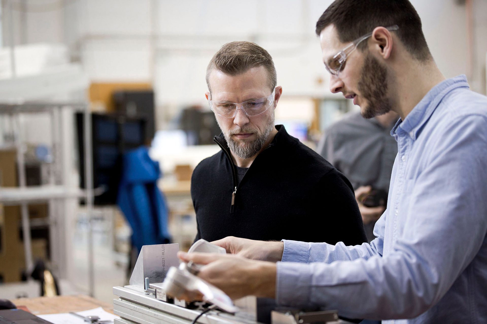 Two men in design workshop looking a small model