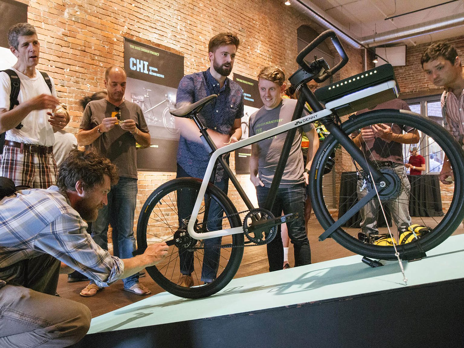 Small group at a party looking at the Denny bike