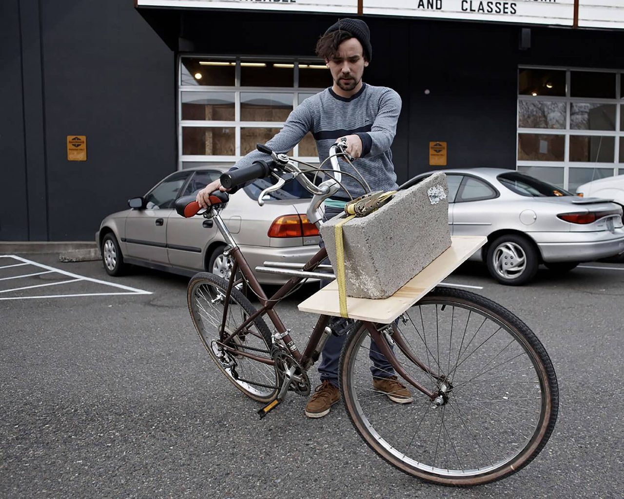 Man testing weight balance on bike using a cinder block