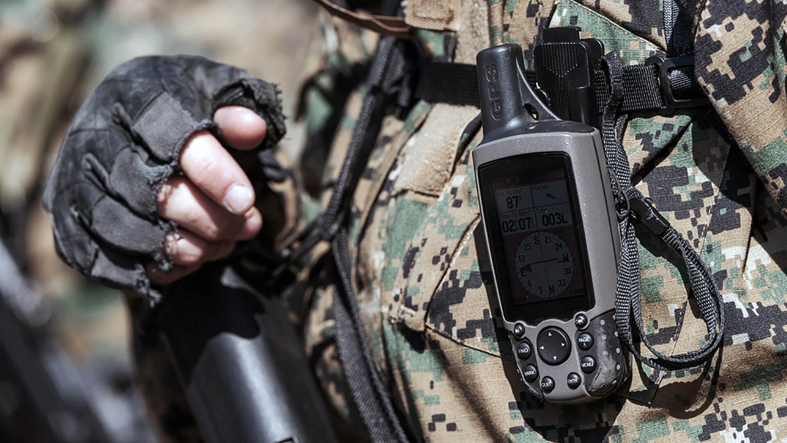 Man in camouflage with personal device