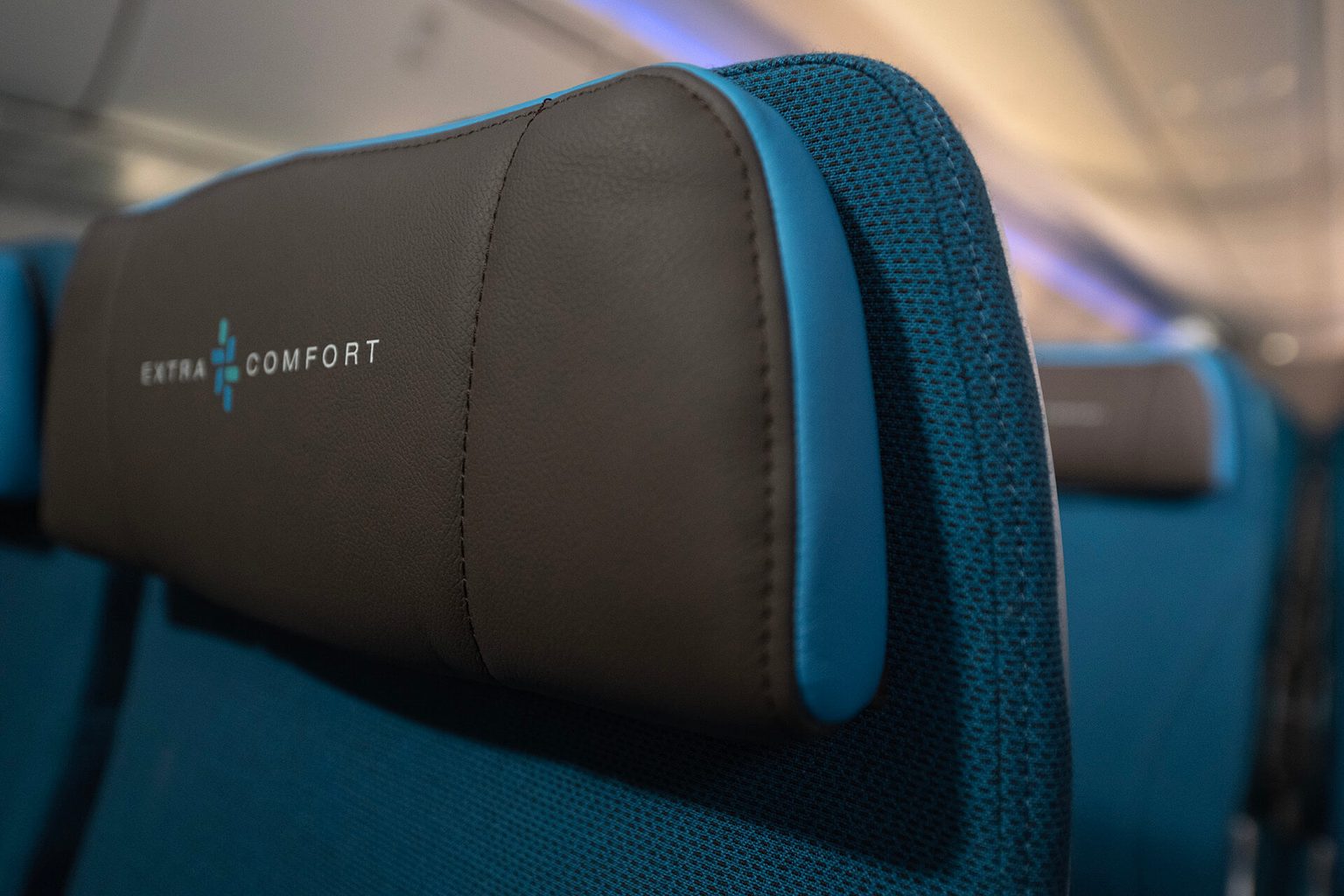 Up close detail of seating headrest in Hawaiian Airlines 787 Extra Comfort Class with blue fabric seat and brown leather headrest