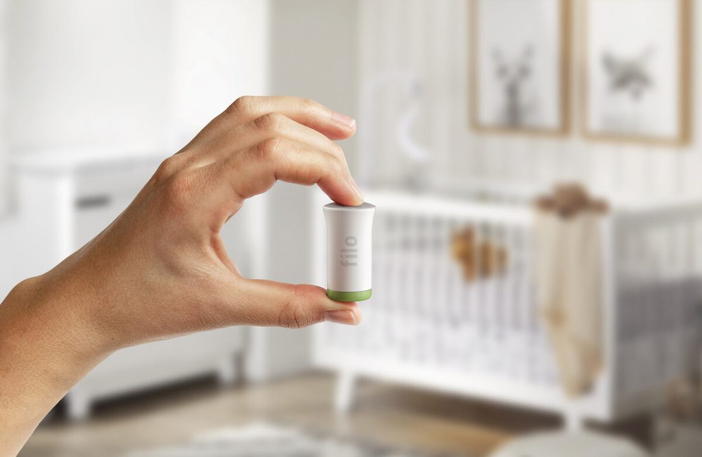 Man holding a Filo smart bulb component in a baby nursery
