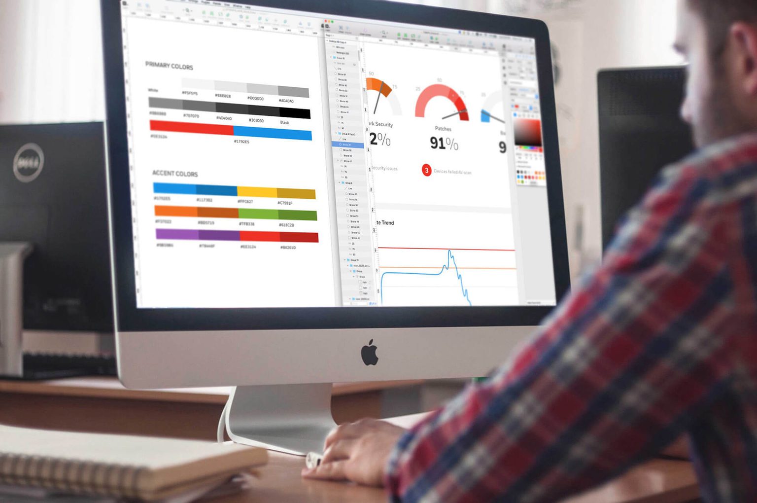 Man in red plaid shirt looking at design guidelines on a Mac computer