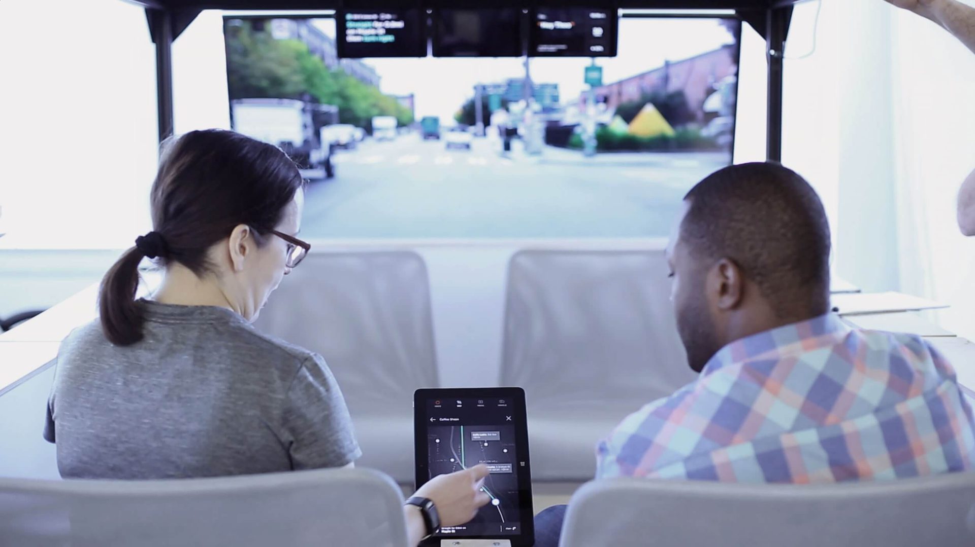Two people sitting in car mock up with large heads up display and small tablet