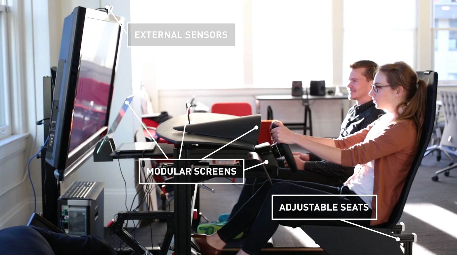 Man and woman sitting in autonomous car driving simulator