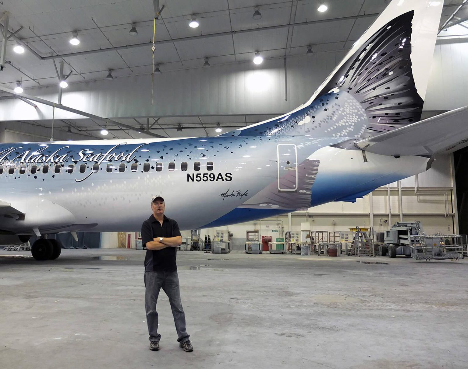 Mark Boyle stands in front of one of his livery designs