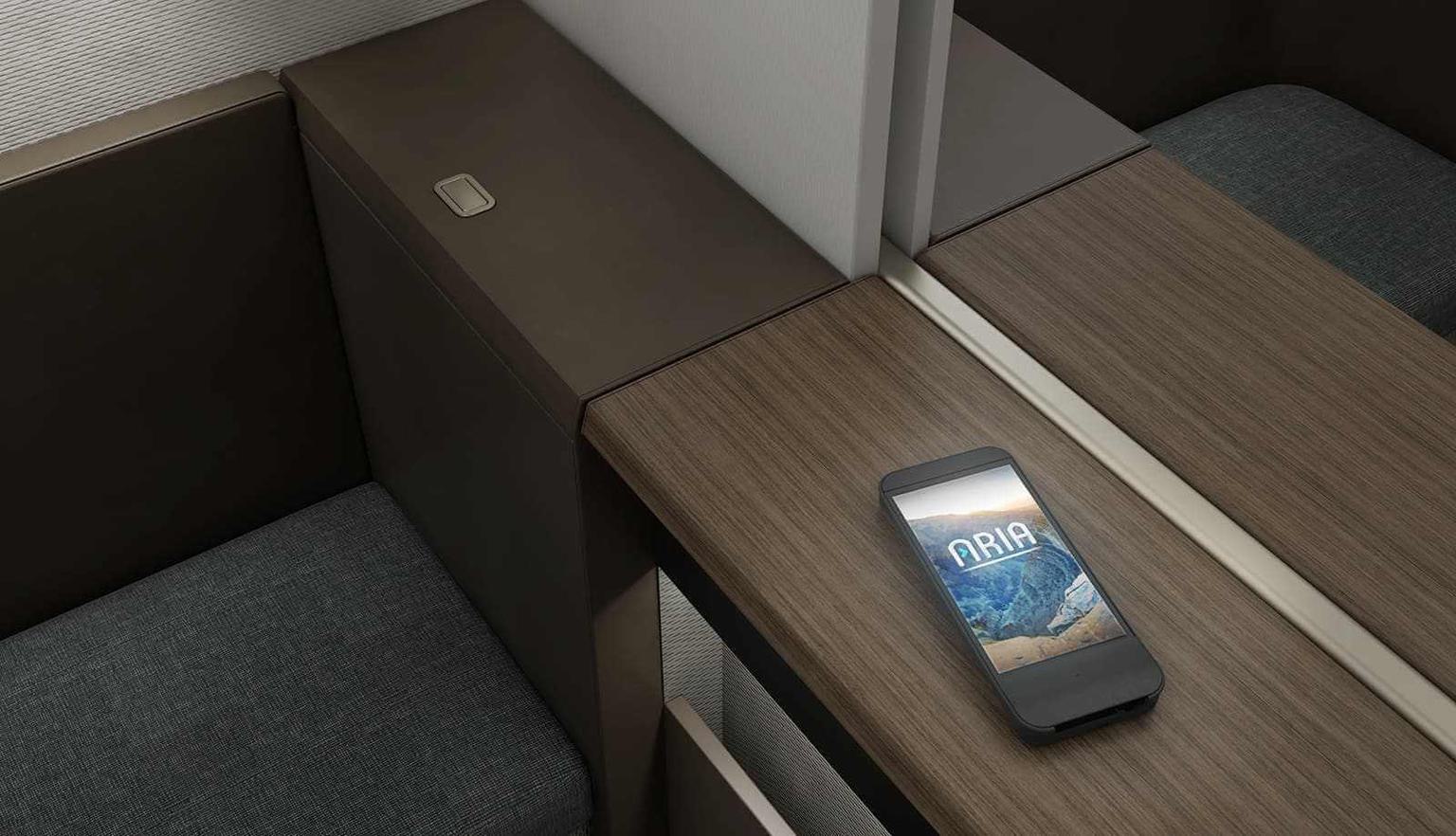 Oman Air 787 First Class passenger seat with phone on inductive charing surface