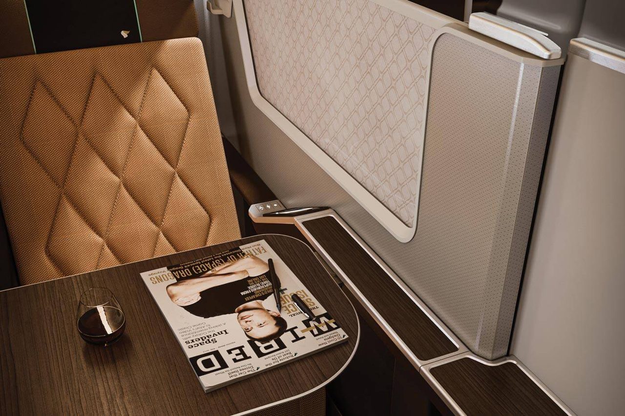 Oman Air Business Class suite with brown quilted seat and pattered privacy divider