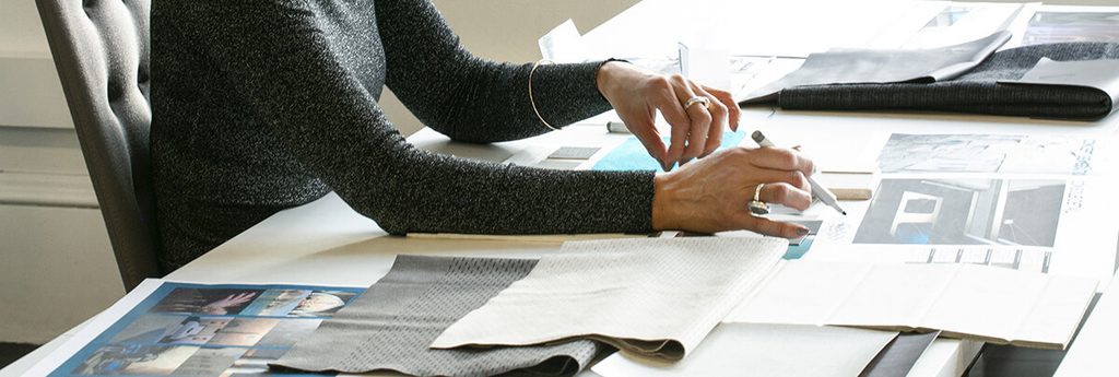 Women sitting at desk review color, material, and finish options for Oman Air