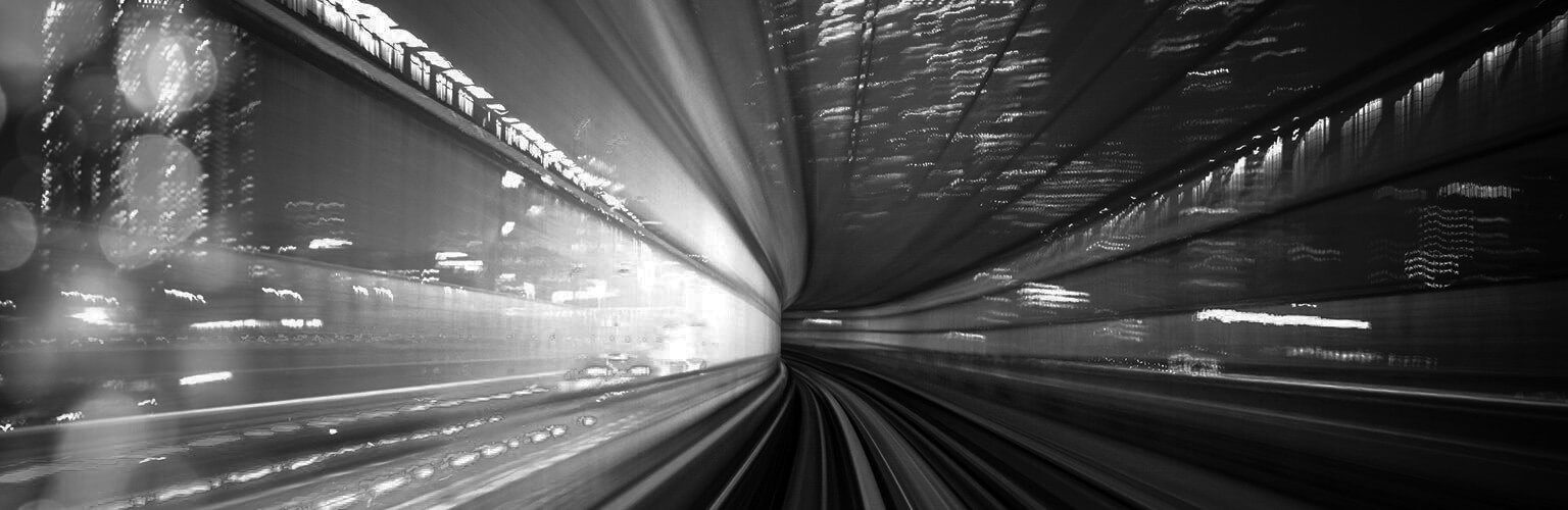 Rail tunnel with city in background