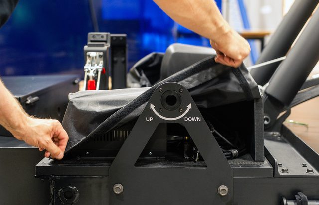 Pair of men's hands adjusting black cloth covering on small trailer