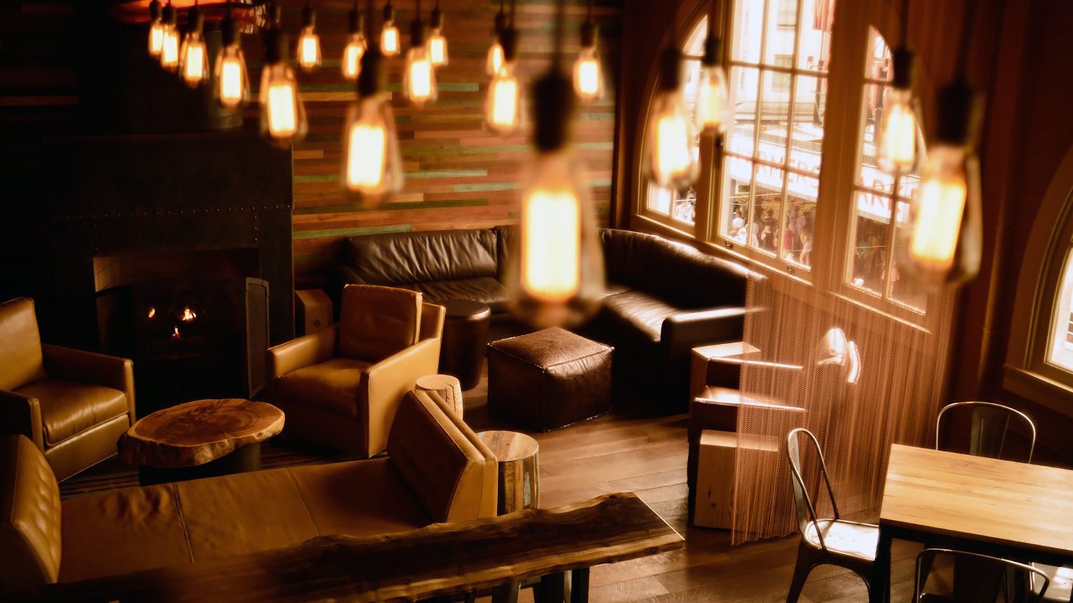 A room with lighting and a couch in the back corner.