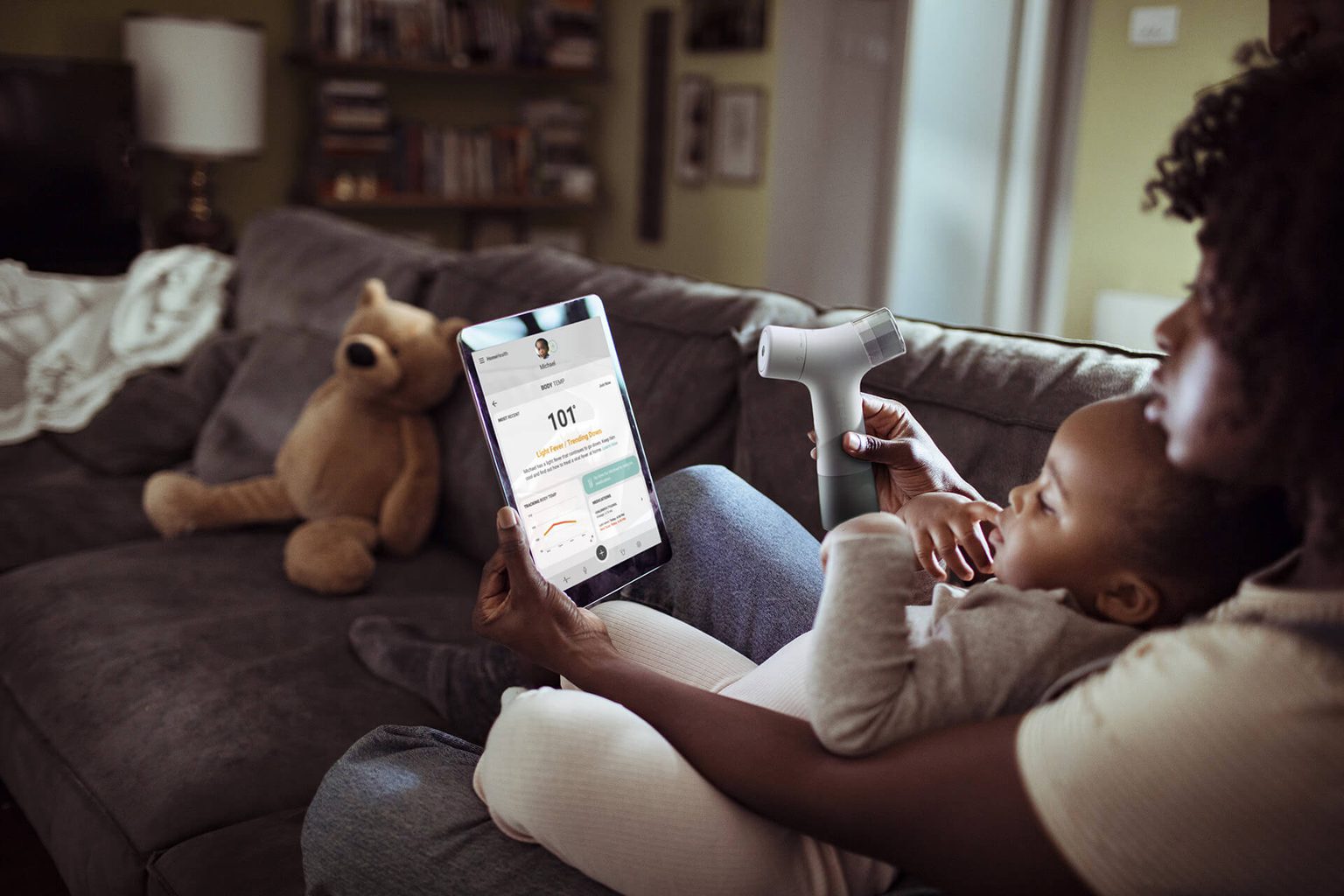 Month and child holder HomeHealth device looking at digital patient records