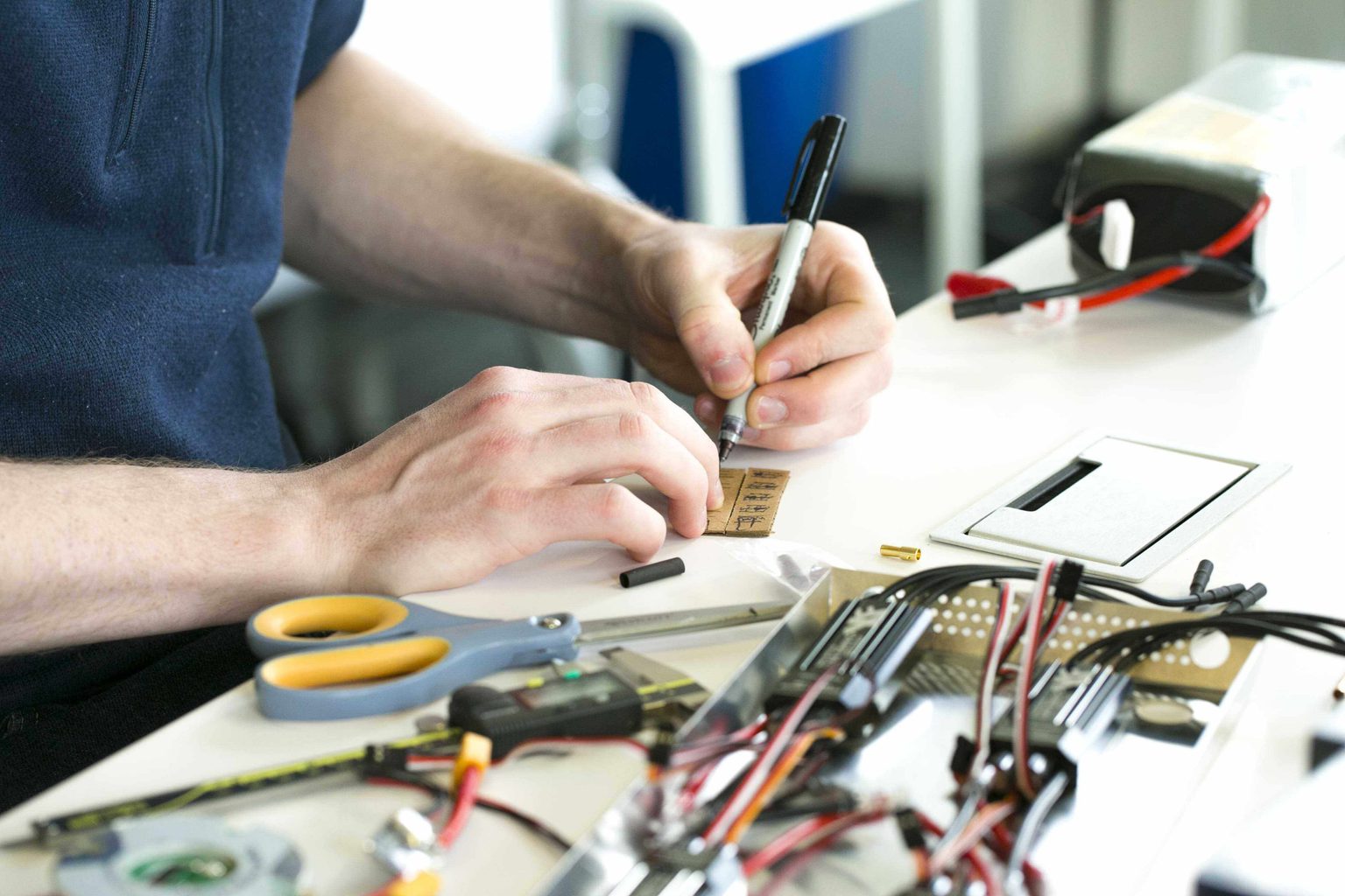 Man soldering on a circuit board in a workshop